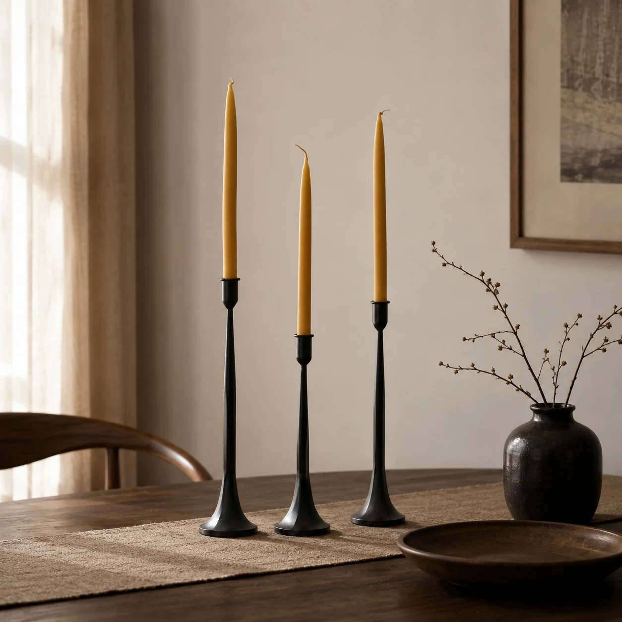 Three taper candle holders styled in a calm dining room setting