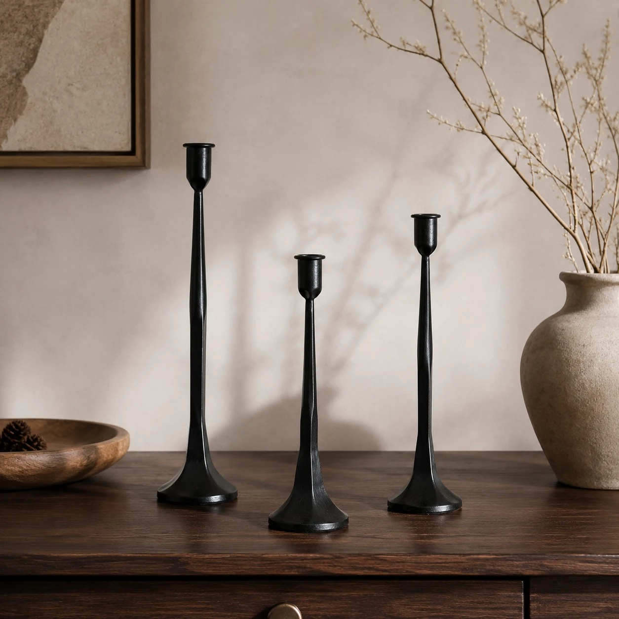 Black iron candle holder set styled on a warm wabi-sabi console table