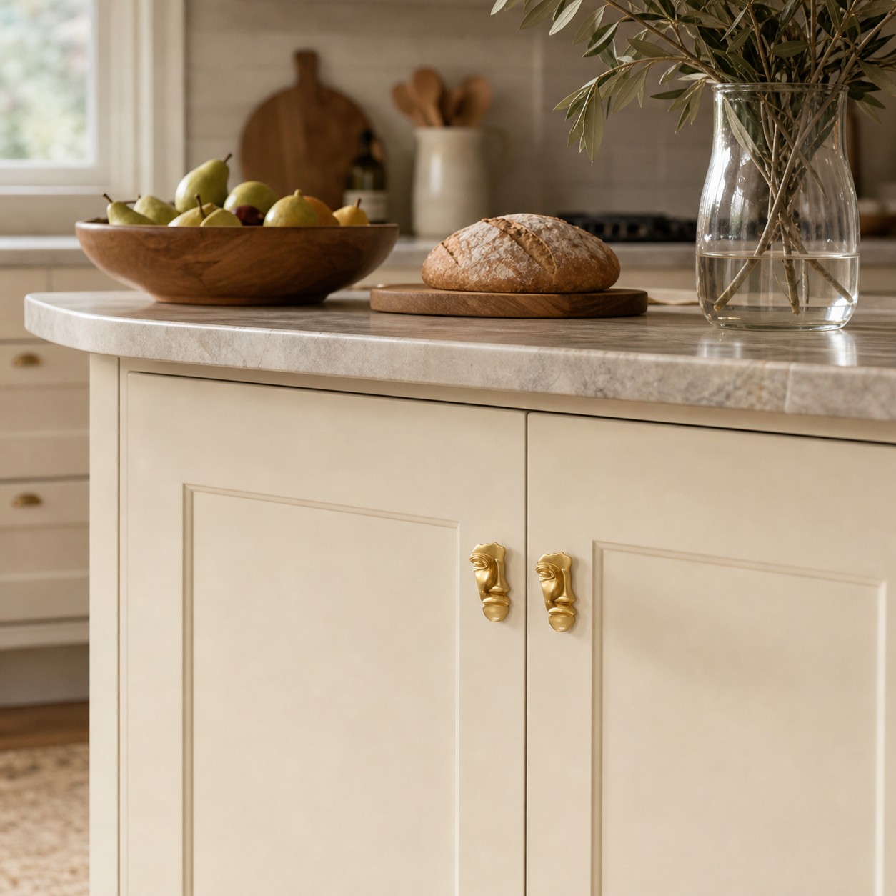 Pair of abstract brass face cabinet knobs on light kitchen cabinetry